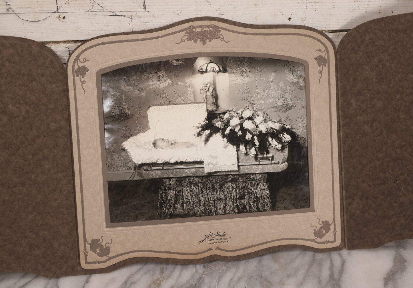 Lot 088 - Vintage Foldered Funeral Photograph Of Elderly Woman In Coffin With Funeral Flowers, From The Art Studio Of Perry Chaloge, Manchester, New Hampshire