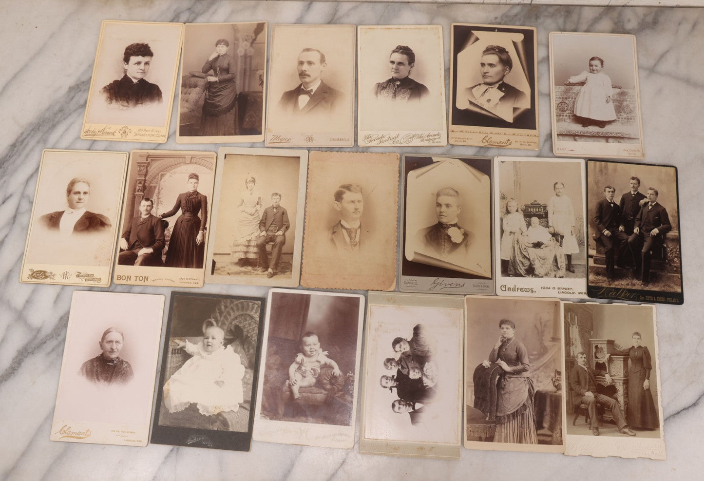 Lot 099 - Grouping Of 19 Antique Cabinet Card Photographs Including Cute Smiling Baby, Three Well Dressed Young Men, And Woman Posing With Photo Album