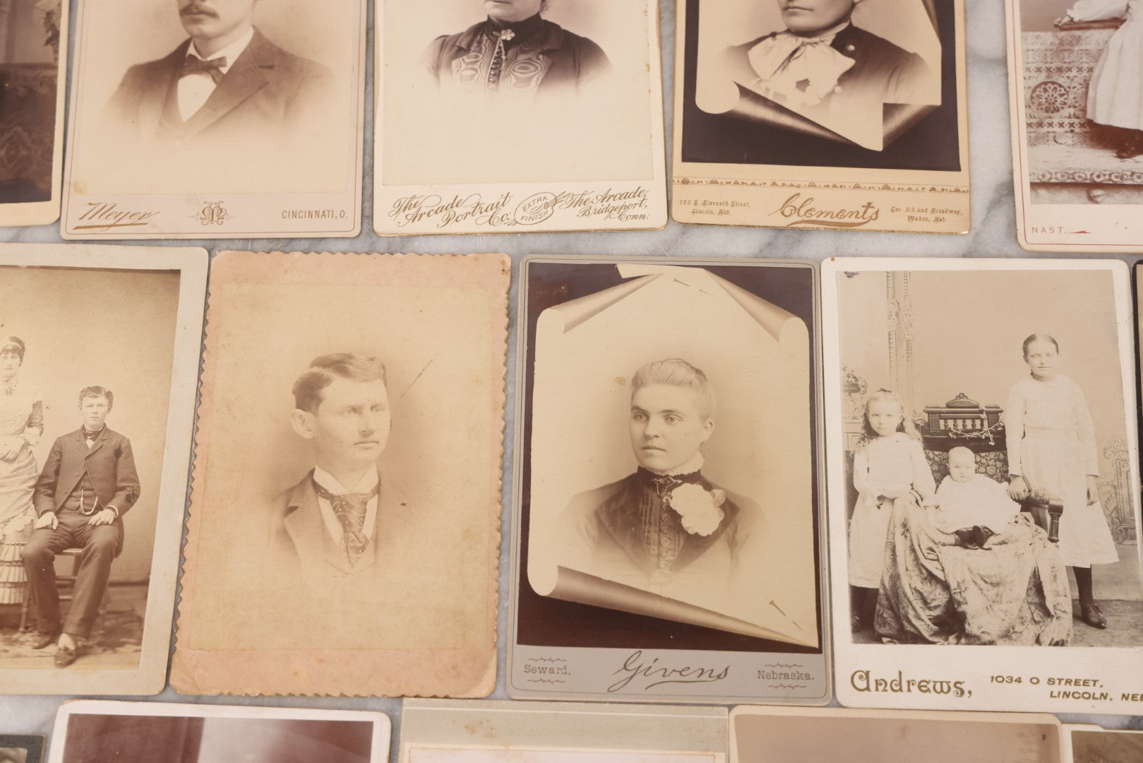 Lot 099 - Grouping Of 19 Antique Cabinet Card Photographs Including Cute Smiling Baby, Three Well Dressed Young Men, And Woman Posing With Photo Album