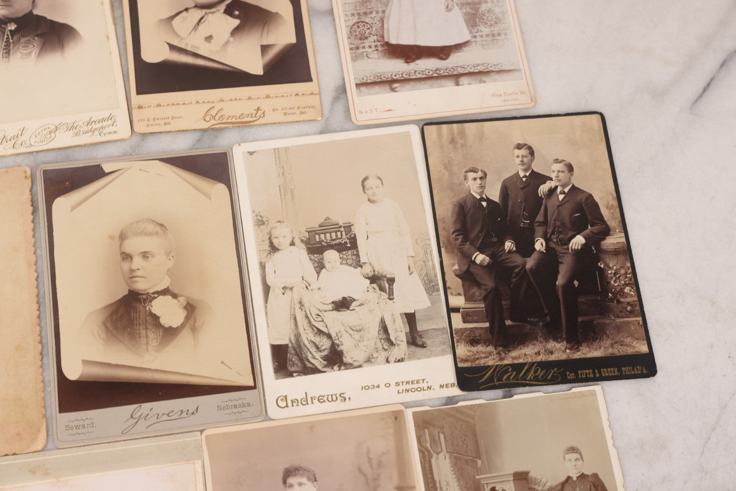 Lot 099 - Grouping Of 19 Antique Cabinet Card Photographs Including Cute Smiling Baby, Three Well Dressed Young Men, And Woman Posing With Photo Album