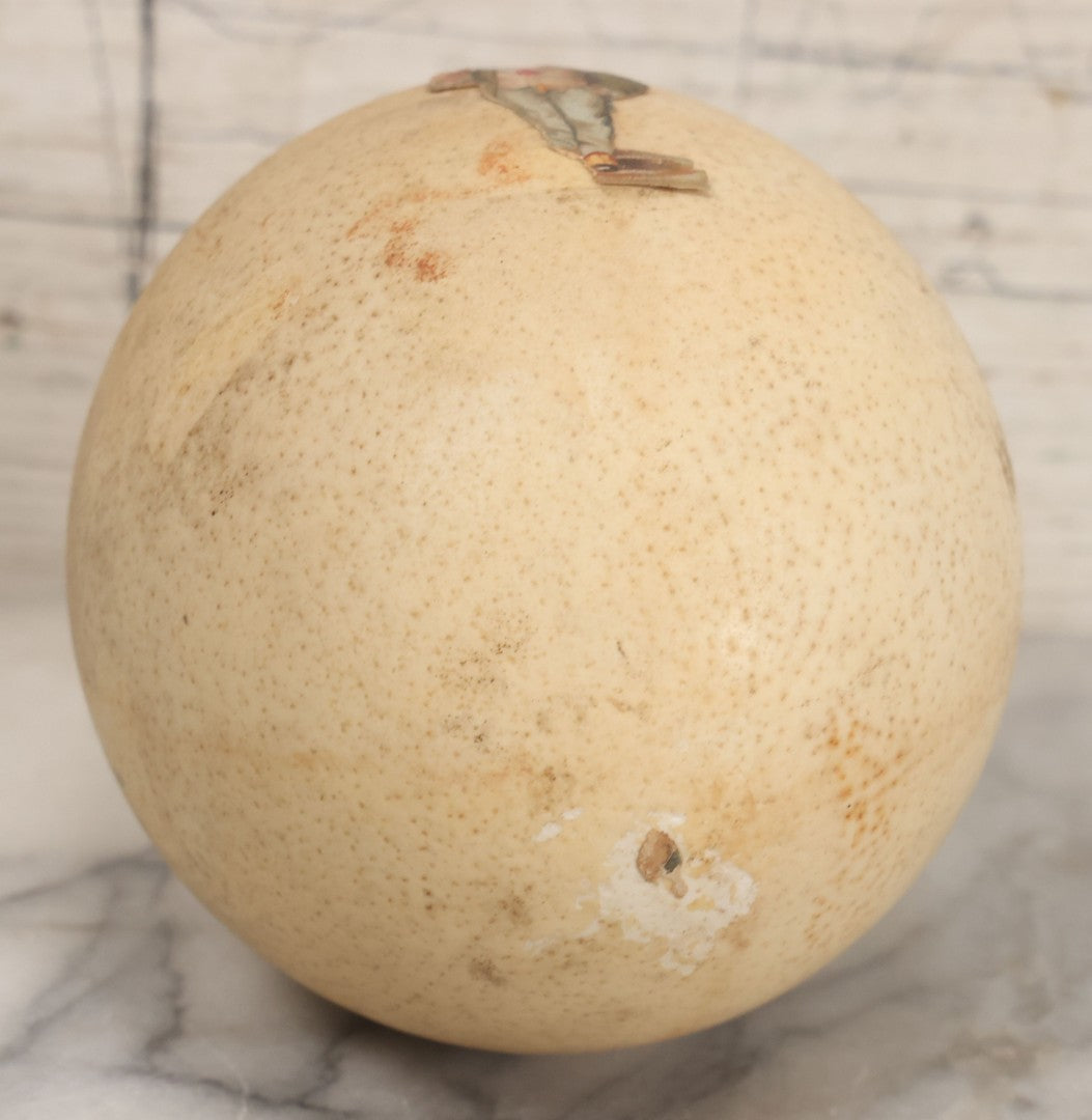Lot 017 - Antique Genuine Ostrich Egg Specimen With Two Applied Victorian Die Cut Scraps Of Cheeky Caricatures, Note Originally Had More Scraps Attached, As Found