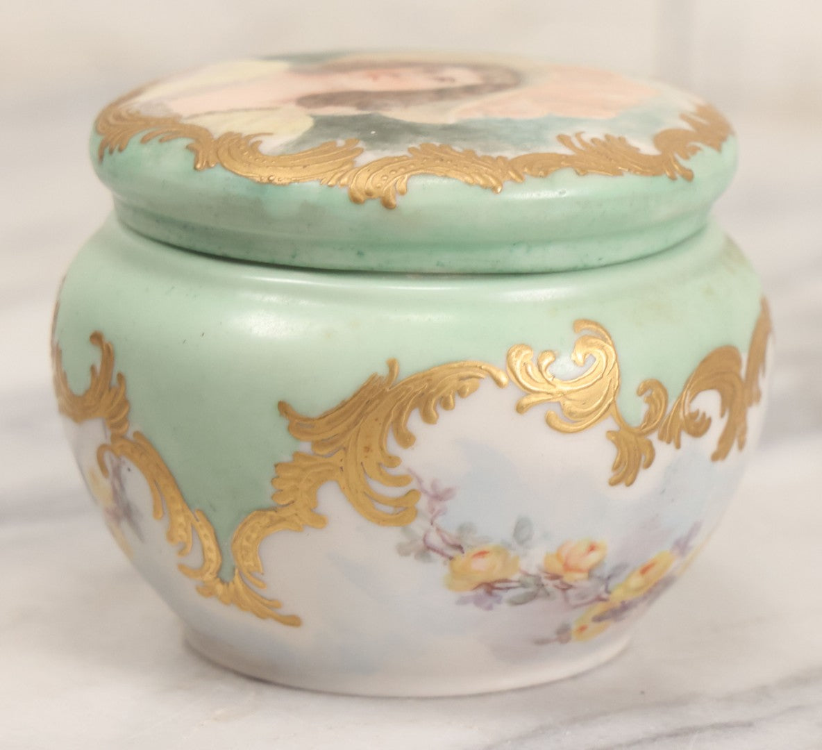 Lot 019 - Antique Hand Painted French Limoges Porcelain Dresser Box With Painting Of Brunette Woman In Extravagant Hat On Lid, With Yellow Painted Flowers, Artist Signed L.C.K. Dated 1894, With Purple "Belleek" Hallmark