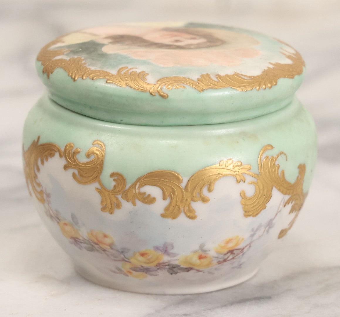 Lot 019 - Antique Hand Painted French Limoges Porcelain Dresser Box With Painting Of Brunette Woman In Extravagant Hat On Lid, With Yellow Painted Flowers, Artist Signed L.C.K. Dated 1894, With Purple "Belleek" Hallmark