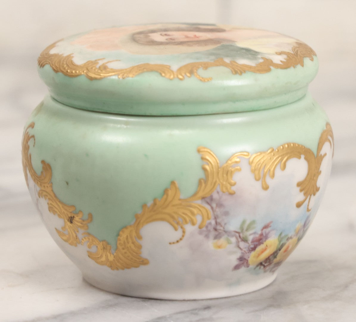 Lot 019 - Antique Hand Painted French Limoges Porcelain Dresser Box With Painting Of Brunette Woman In Extravagant Hat On Lid, With Yellow Painted Flowers, Artist Signed L.C.K. Dated 1894, With Purple "Belleek" Hallmark