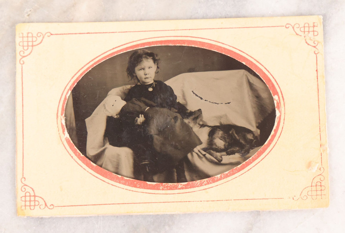 Lot 063 - Antique Tintype Photograph Of Little Girl Posing With Large Doll And Scraggly Little Dog, Photo In Landscape Orientation, In Paper Frame