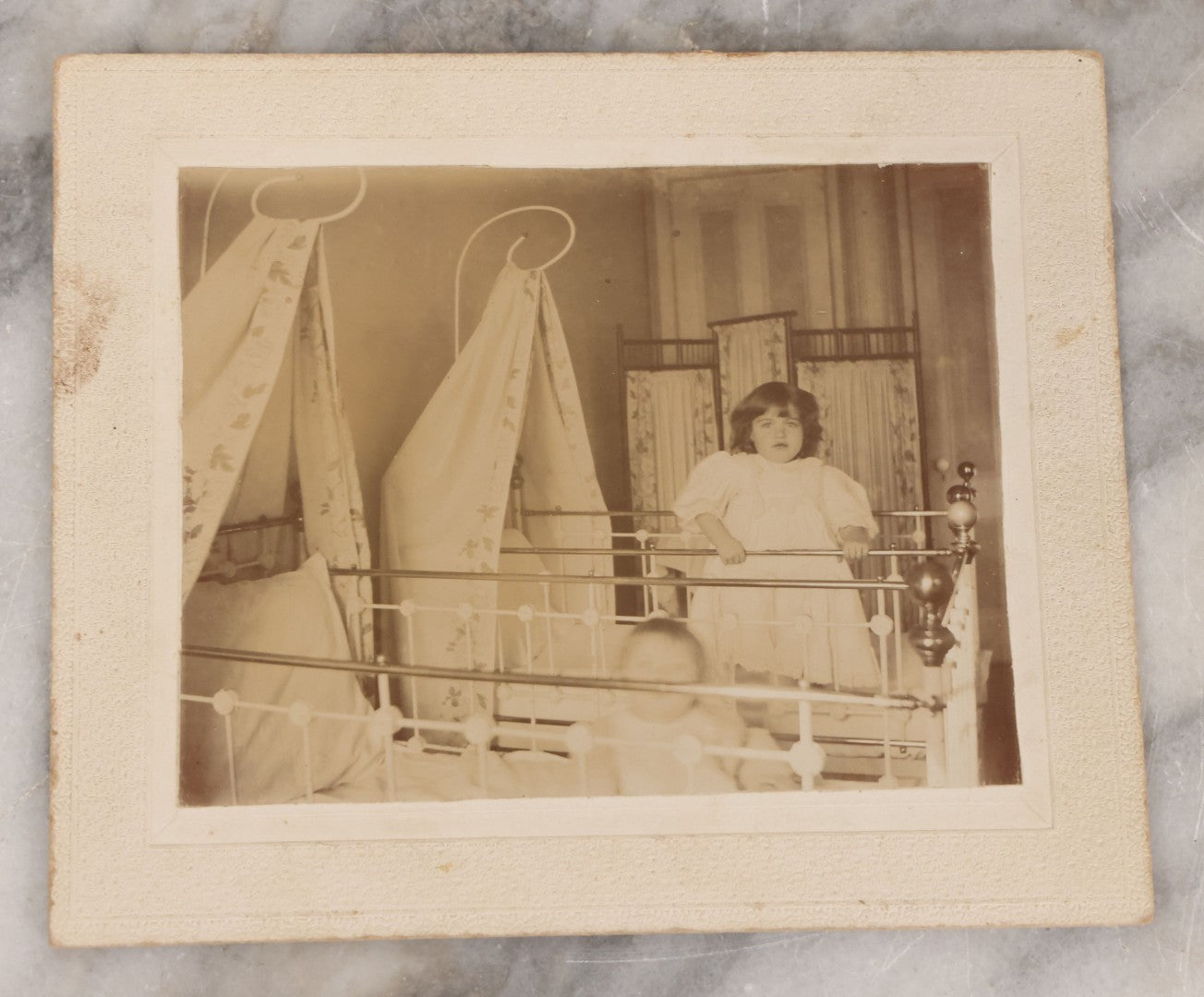 Lot 070 - Grouping Of Seven Antique Photographs Of Children, Including Makeshift Frame Of Girl In Four Views, Children Posing On New York City Stoop, Children In Cribs, Boy Posing With Toys