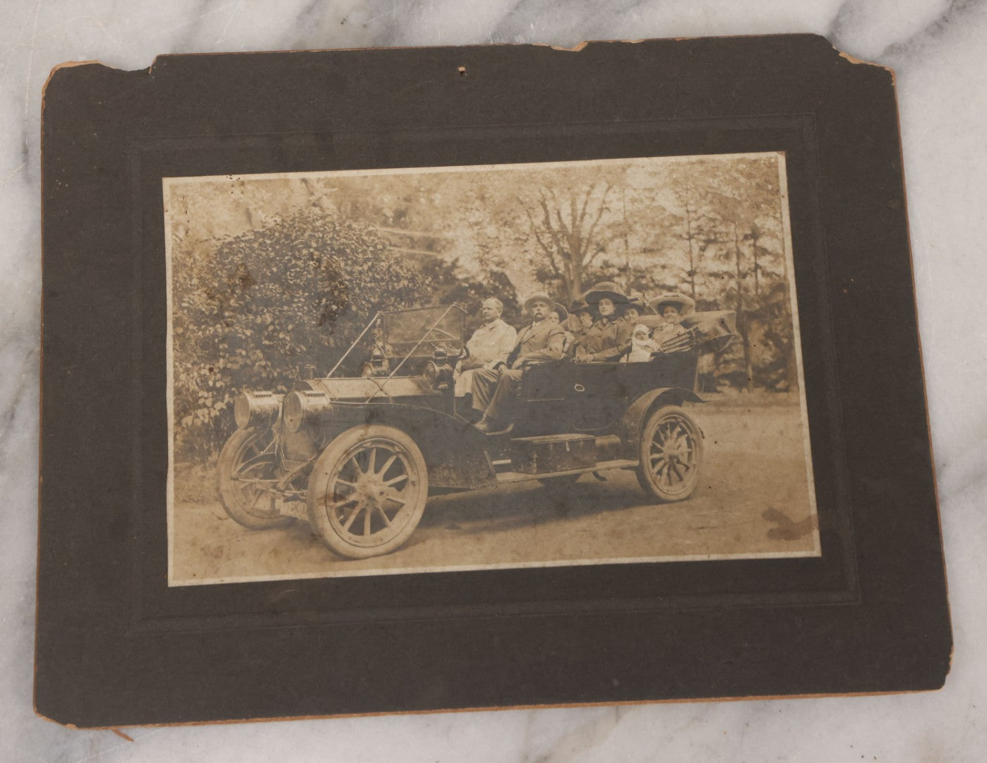 Lot 078 - Grouping Of Six Antique Boarded Outdoor Photographs Including Group In Car, Tent Decorated For Dinner Party, Couple Laughing In Tree, And Western Cabin