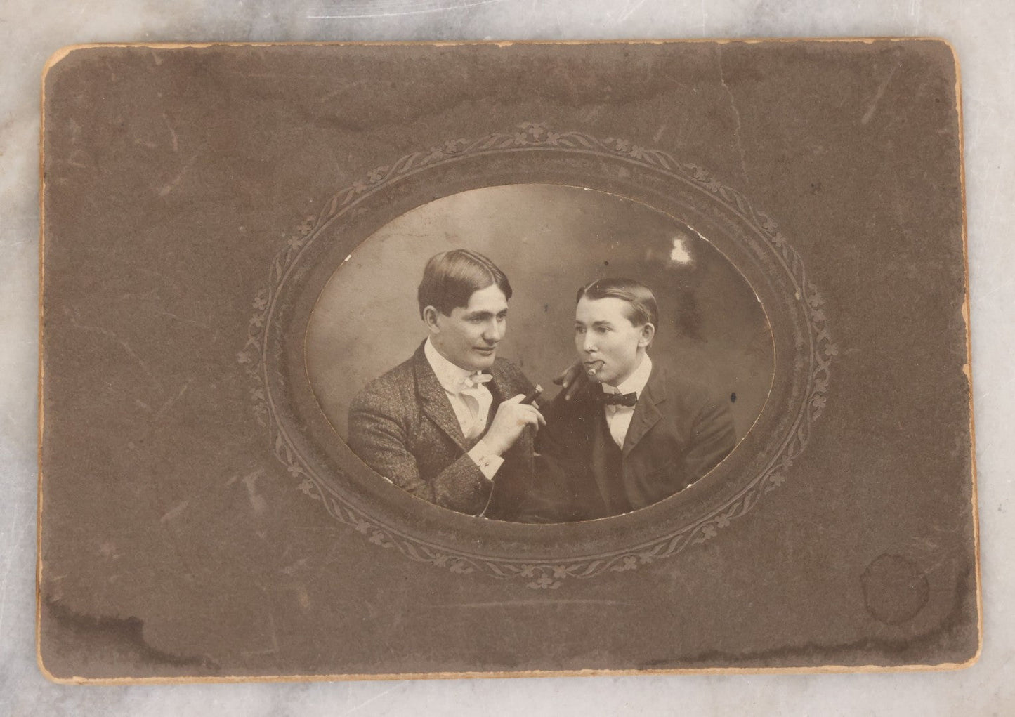 Lot 083 - Antique Boarded Photograph Of Two Young Men Enjoying Cigars, One Wearing A Knowing Smirk, J.E. Taylor, Photographer