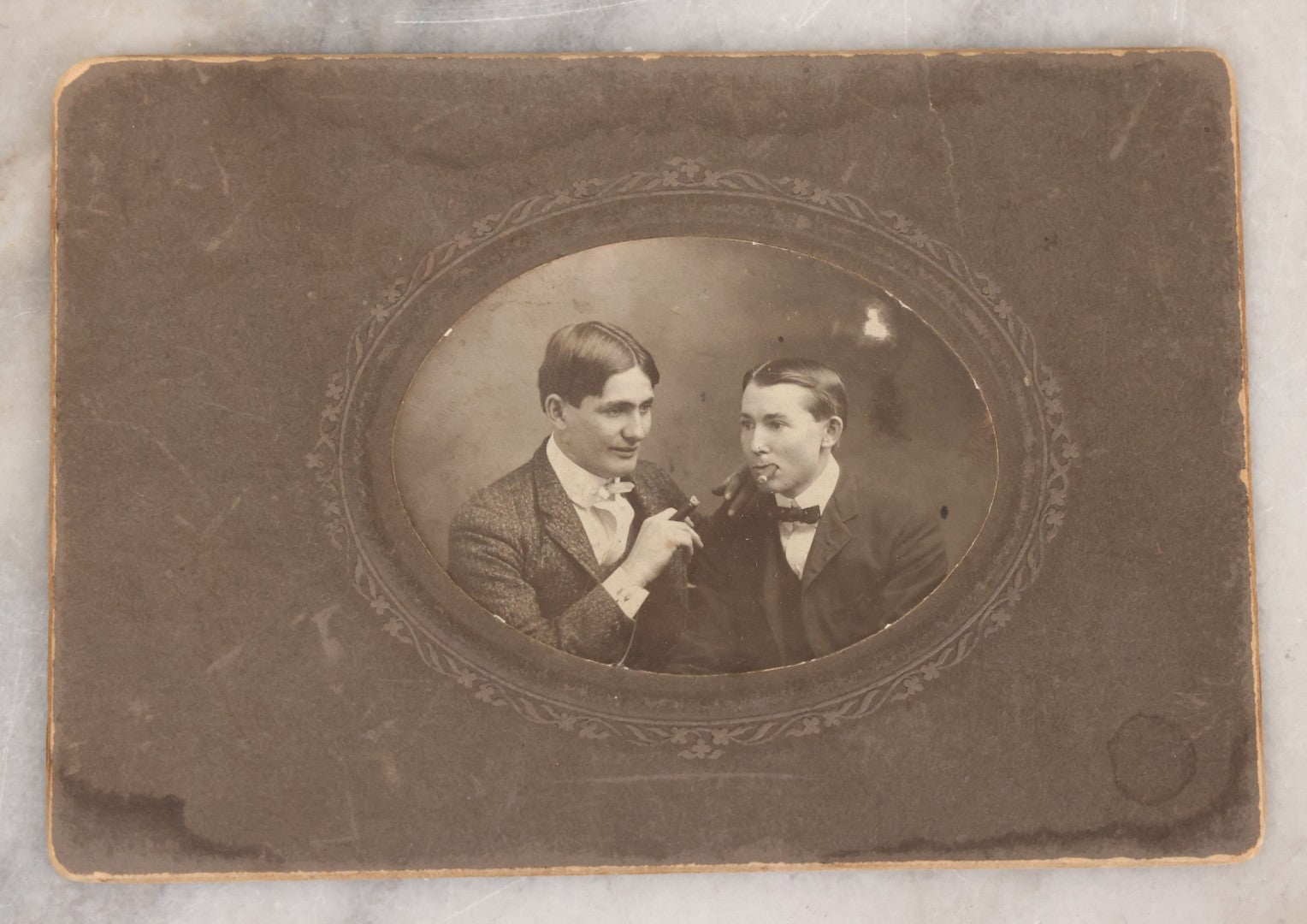 Lot 083 - Antique Boarded Photograph Of Two Young Men Enjoying Cigars, One Wearing A Knowing Smirk, J.E. Taylor, Photographer