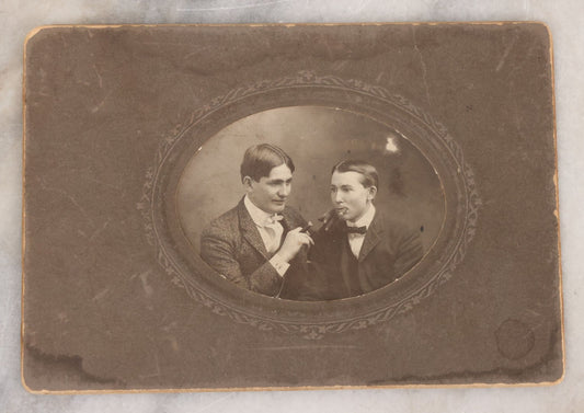 Lot 083 - Antique Boarded Photograph Of Two Young Men Enjoying Cigars, One Wearing A Knowing Smirk, J.E. Taylor, Photographer