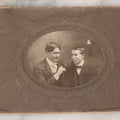 Lot 083 - Antique Boarded Photograph Of Two Young Men Enjoying Cigars, One Wearing A Knowing Smirk, J.E. Taylor, Photographer