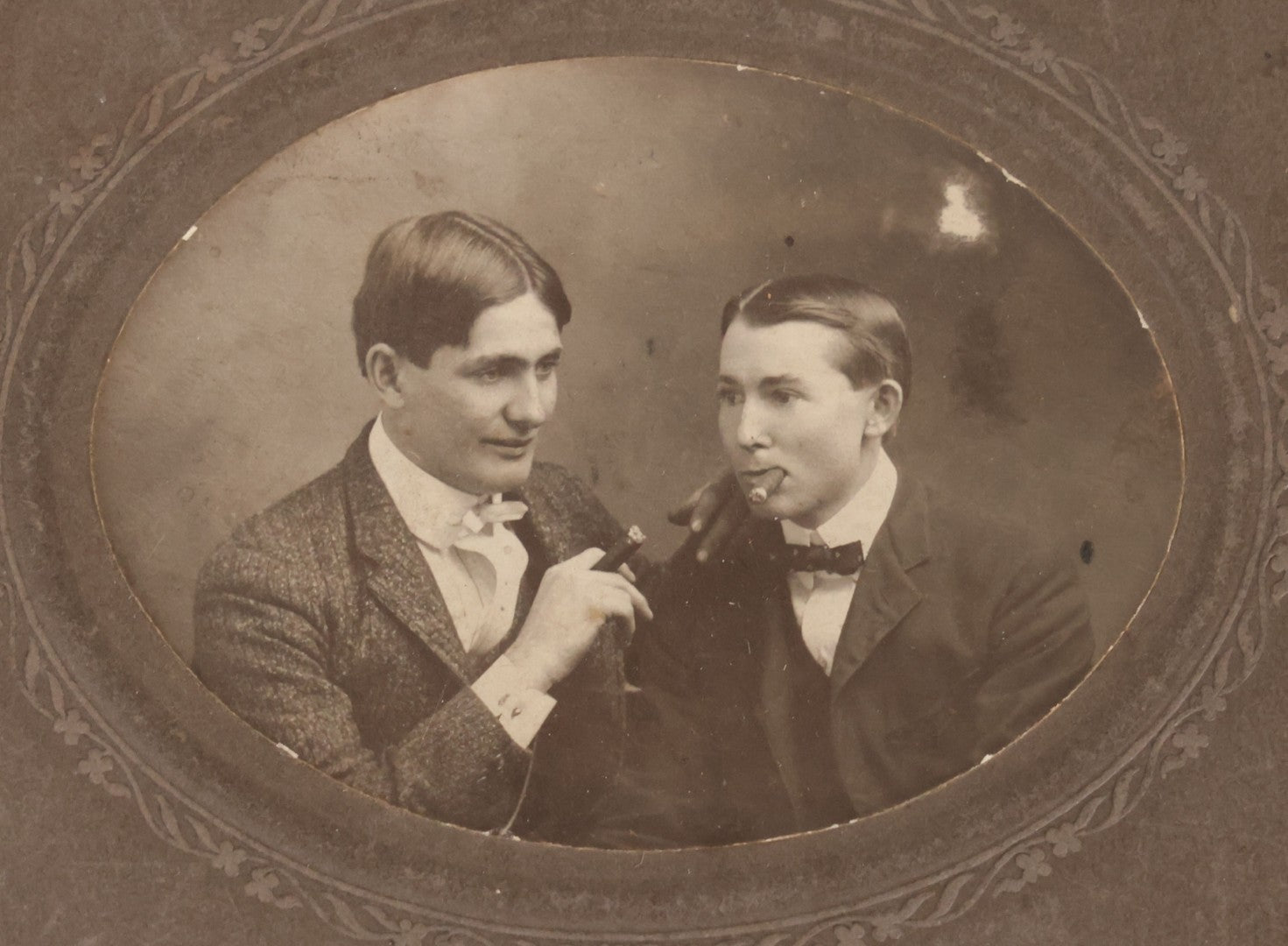 Lot 083 - Antique Boarded Photograph Of Two Young Men Enjoying Cigars, One Wearing A Knowing Smirk, J.E. Taylor, Photographer