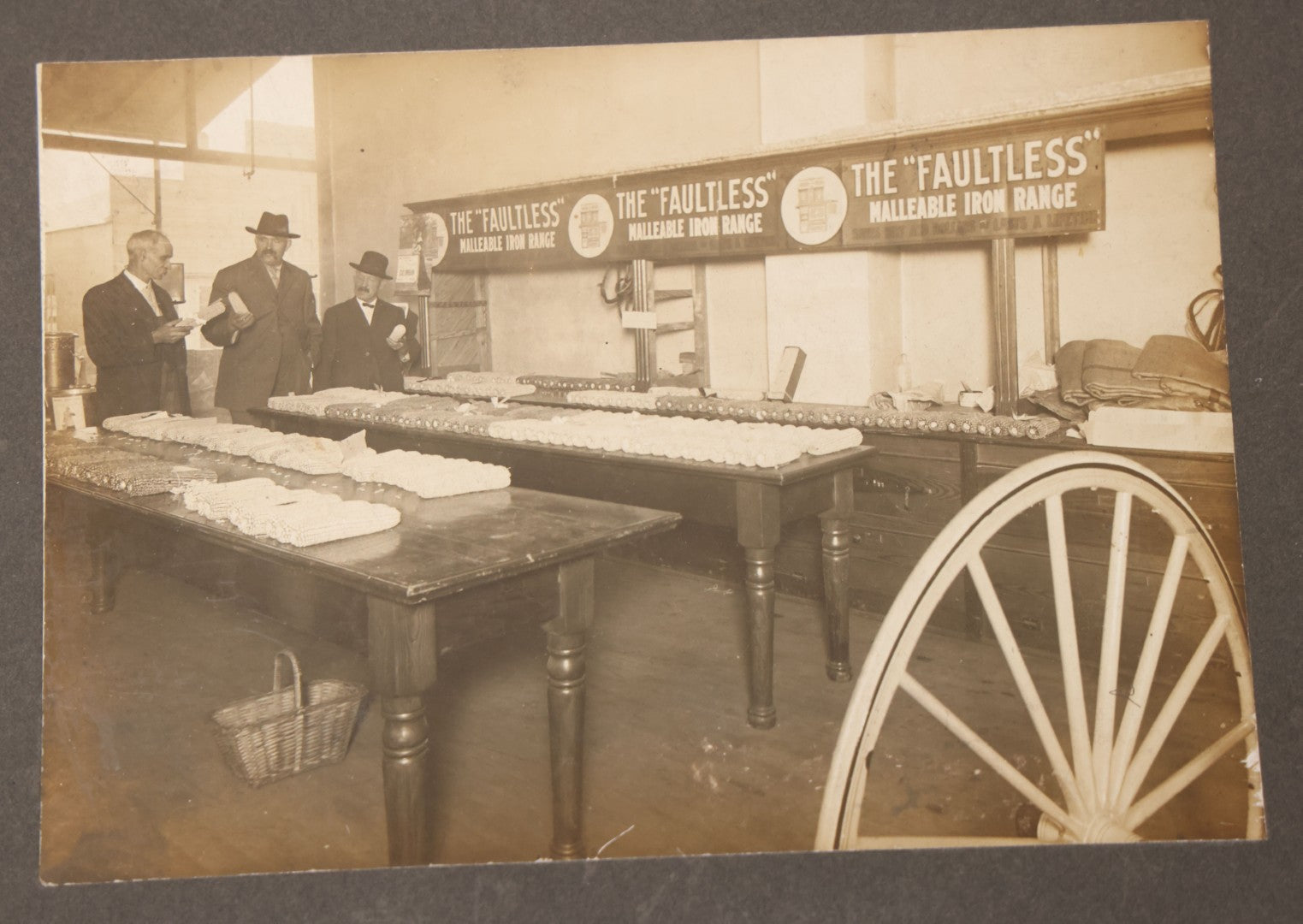 Lot 084 - Antique Boarded Occupational Photograph Of Three Men Inspecting A Large Variety Of Corn, With Advertisement For "The 'Faultless' Malleable Iron Range" In Background