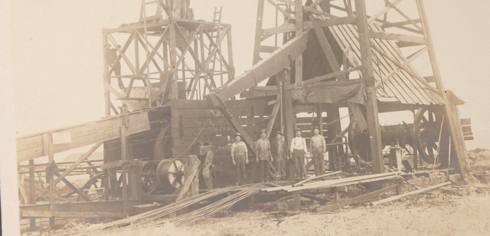 Lot 085 - Antique Boarded Occupational Photograph Of Six Men Posing At The Foot Of A Period Oil Well Rig