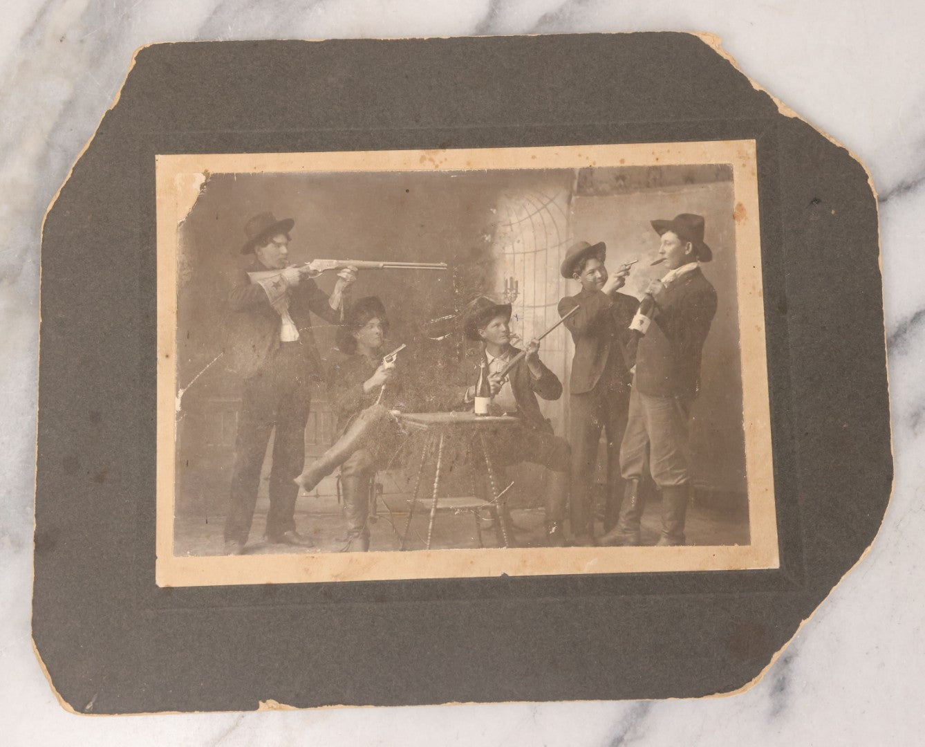 Lot 086 - Antique Boarded Studio Photograph Of Four Boys Drinking, Smoking, And Pointing Guns At Their Buddy