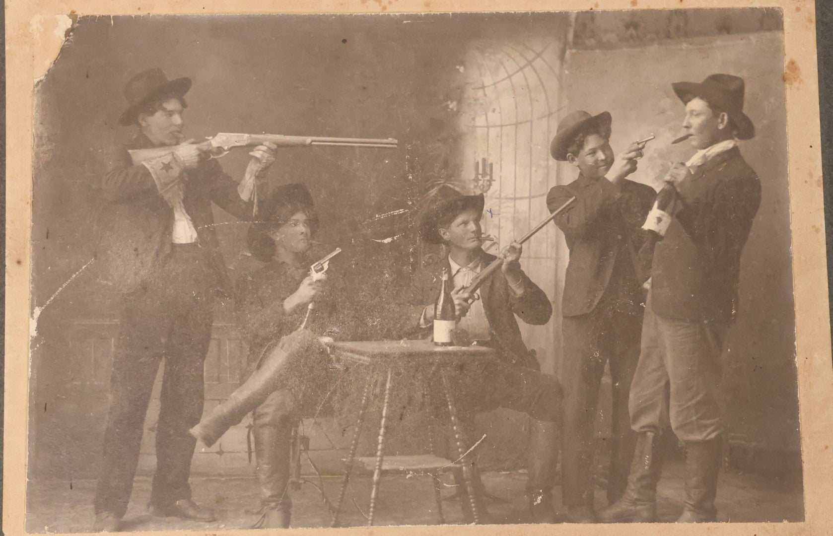 Lot 086 - Antique Boarded Studio Photograph Of Four Boys Drinking, Smoking, And Pointing Guns At Their Buddy