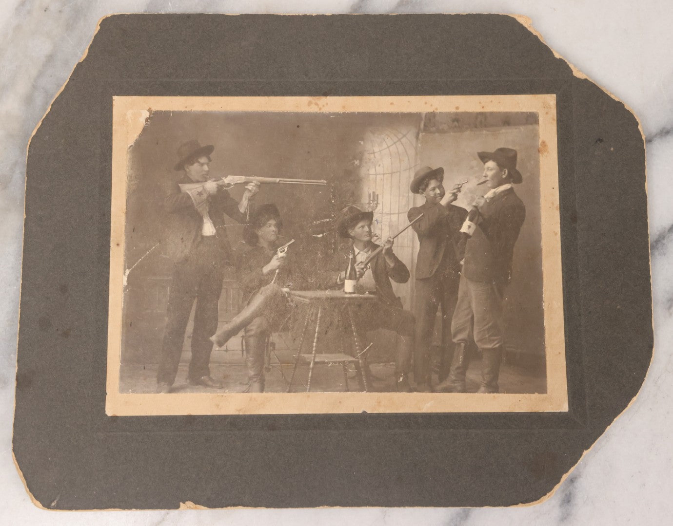 Lot 086 - Antique Boarded Studio Photograph Of Four Boys Drinking, Smoking, And Pointing Guns At Their Buddy