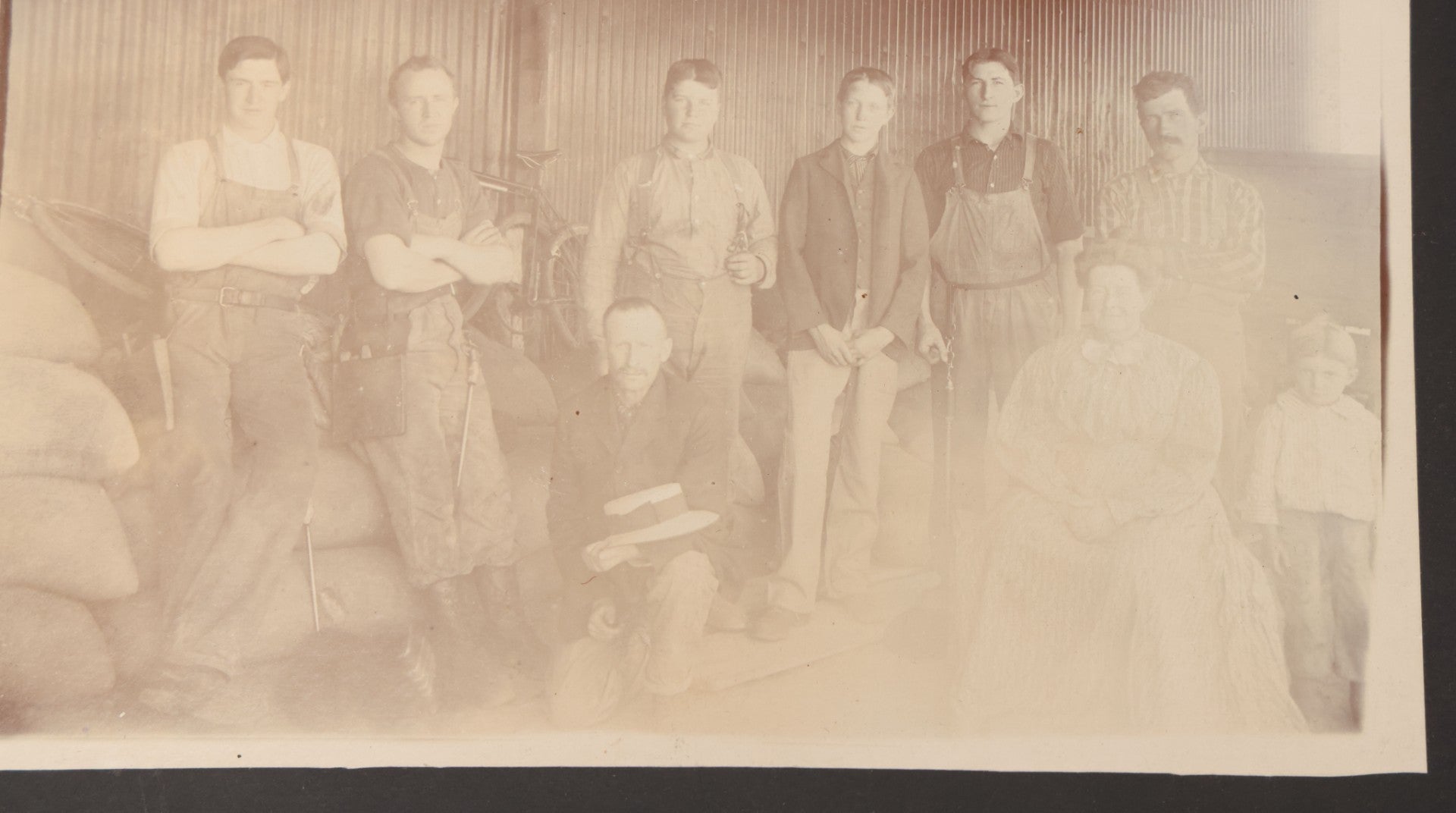 Lot 088 - Antique Boarded Occupational Photograph Of Group Of Workers, Unknown Trade, Posing On A Pile Of Sacks With Bicycles In Background