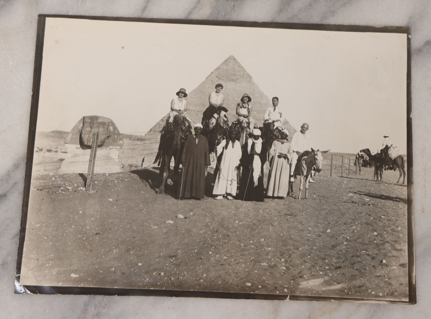 Lot 090 - Antique Unmounted Photograph Of Group Of Tourists On Camels Posing With Tour Guides In Front Of Great Pyramid Of Giza And Sphinx