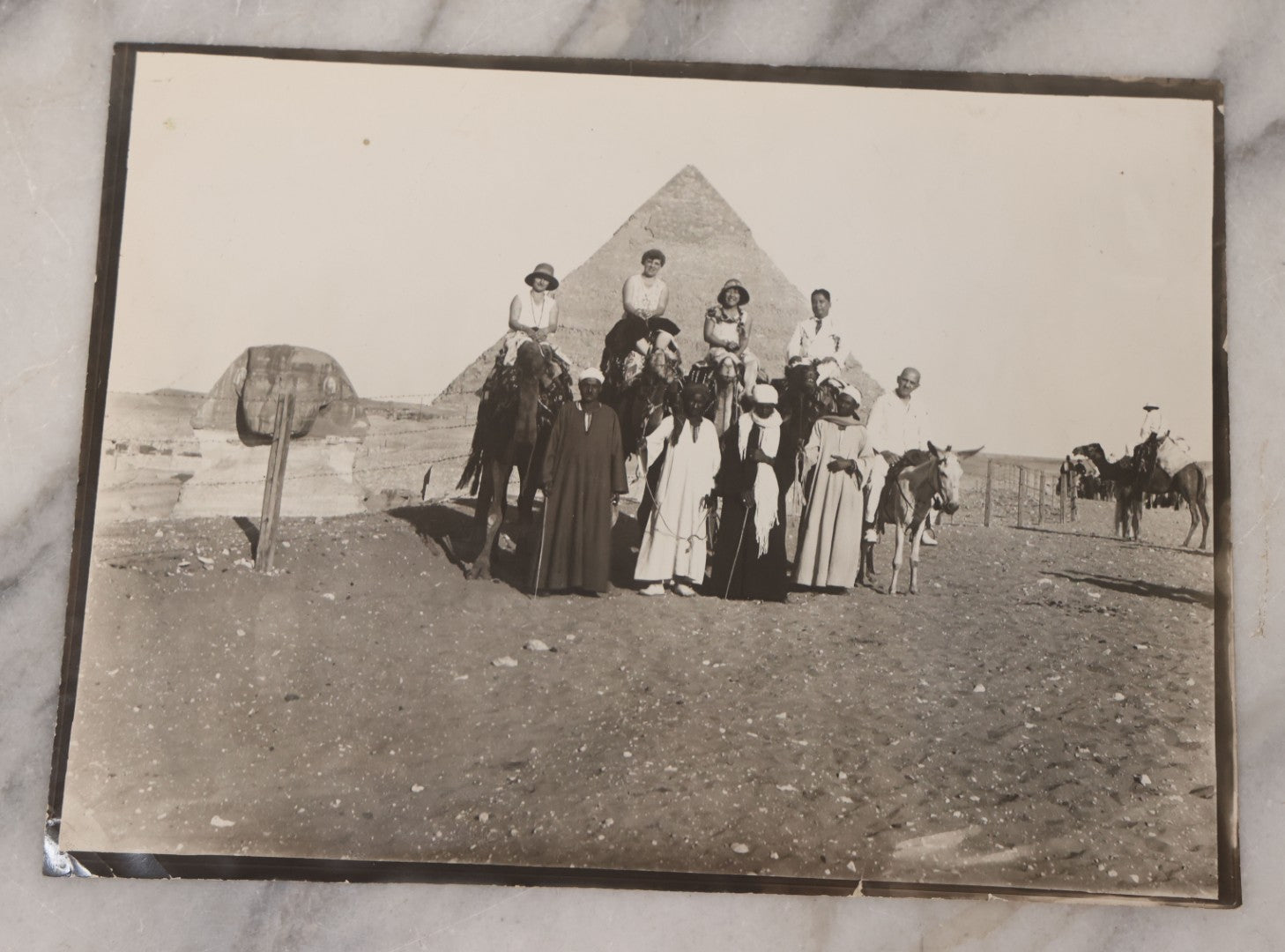 Lot 090 - Antique Unmounted Photograph Of Group Of Tourists On Camels Posing With Tour Guides In Front Of Great Pyramid Of Giza And Sphinx