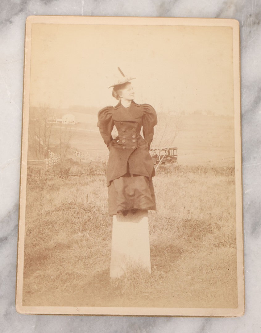 Lot 102 - Antique Boarded Photograph Of Woman In Peacoat Posing On Top Of Property Marker Pillar And Staring Fondly At The Sky, Farm In Background