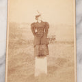 Lot 102 - Antique Boarded Photograph Of Woman In Peacoat Posing On Top Of Property Marker Pillar And Staring Fondly At The Sky, Farm In Background