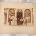 Lot 111 - Antique Boarded Occupational Photograph Of Workers And Dressmakers Posing Outside Their Shop, With Many Signs And Advertisements In Photo, Note Photo Has Large Crease Through Center On Verso