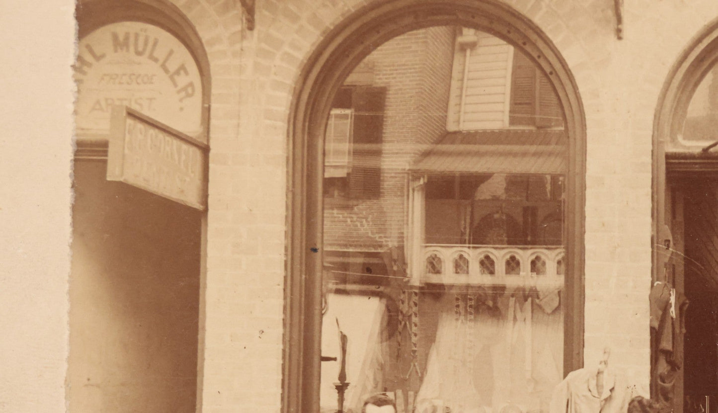 Lot 111 - Antique Boarded Occupational Photograph Of Workers And Dressmakers Posing Outside Their Shop, With Many Signs And Advertisements In Photo, Note Photo Has Large Crease Through Center On Verso