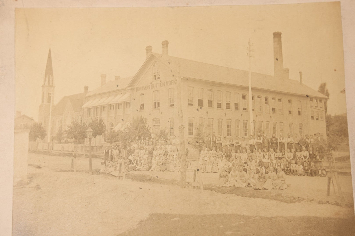 Lot 112 - Antique Boarded Occupational Photograph Of Large Group Of Workers Of The Dominion Button Works Factory, Ontario, Canada