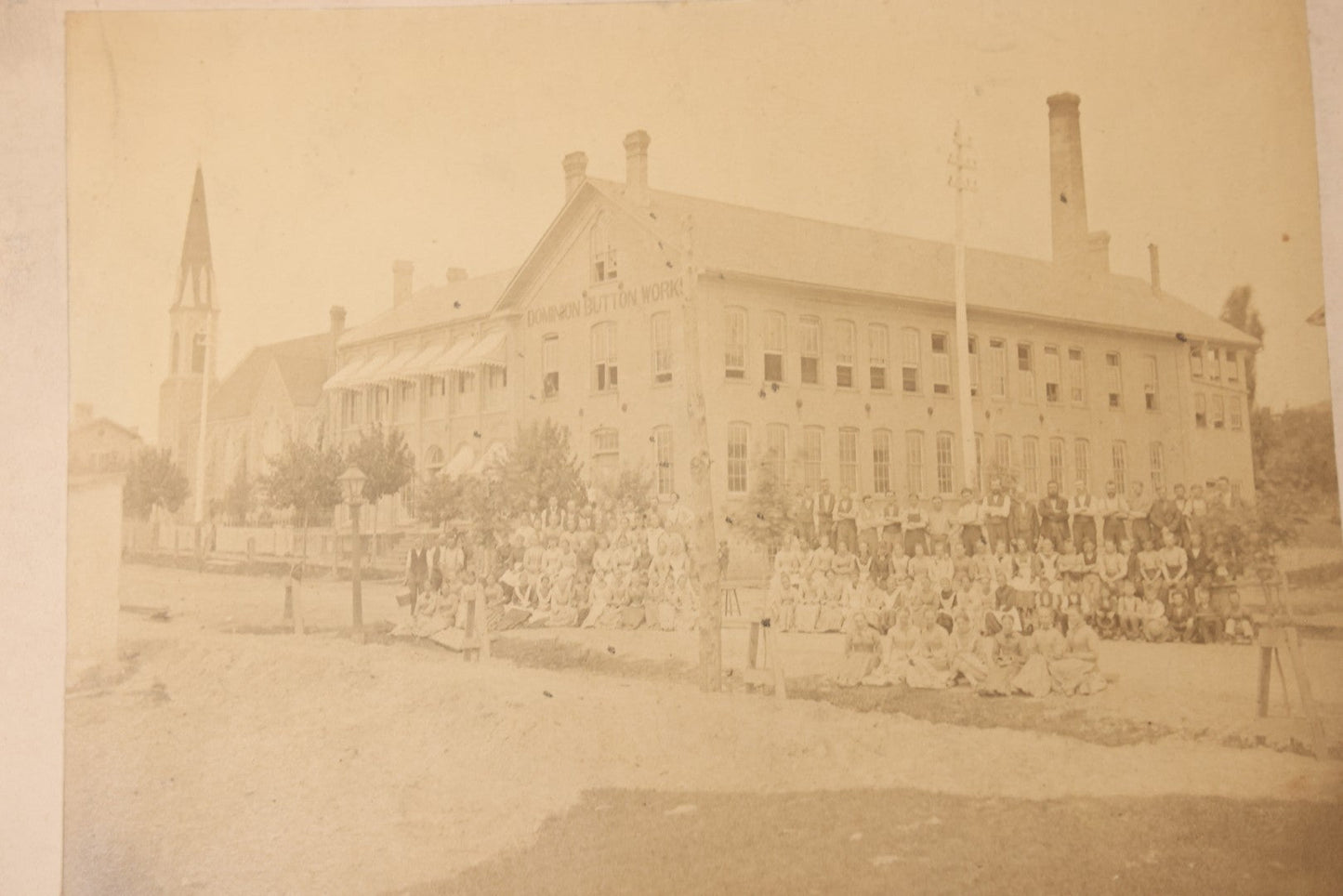 Lot 112 - Antique Boarded Occupational Photograph Of Large Group Of Workers Of The Dominion Button Works Factory, Ontario, Canada