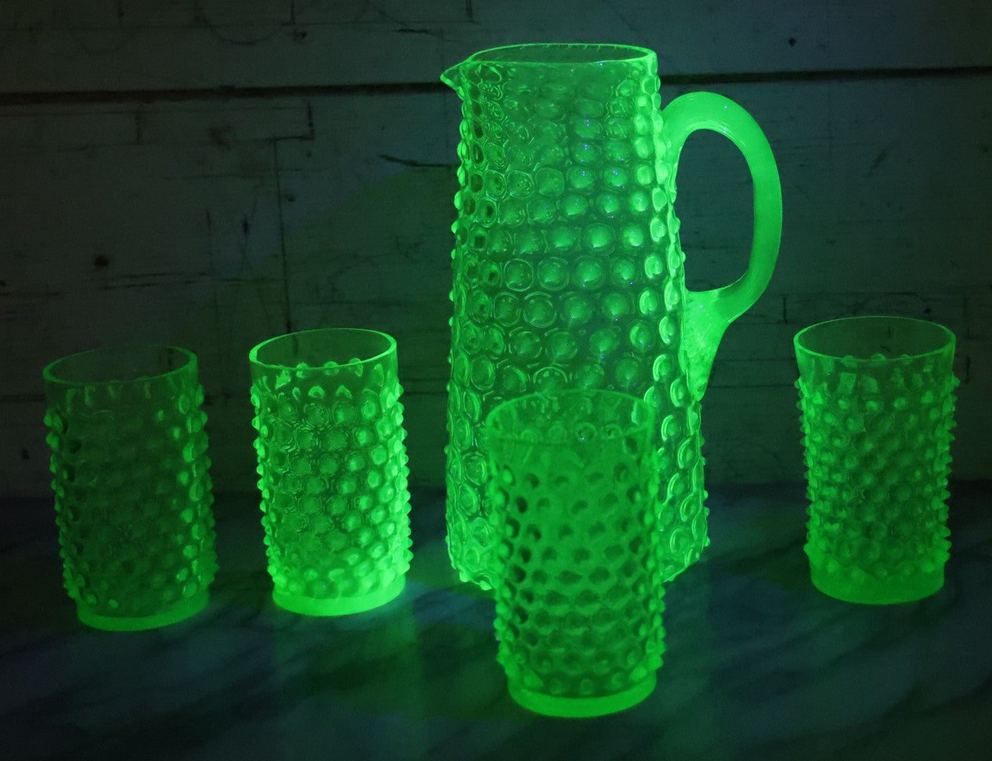 Lot 014 - Vintage Six Piece Hobnail Uranium Glass Drinking Collection With Pitcher And Four Matching Cups Plus Additional Cup, U.V. Blacklight Reactive Glass, Note Chips And Cracks