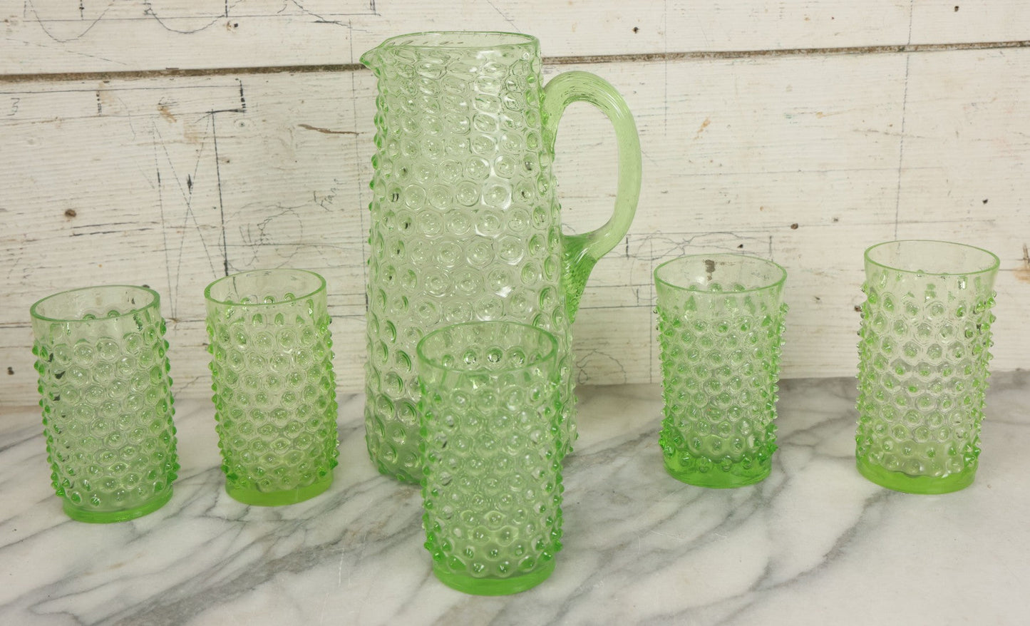 Lot 014 - Vintage Six Piece Hobnail Uranium Glass Drinking Collection With Pitcher And Four Matching Cups Plus Additional Cup, U.V. Blacklight Reactive Glass, Note Chips And Cracks
