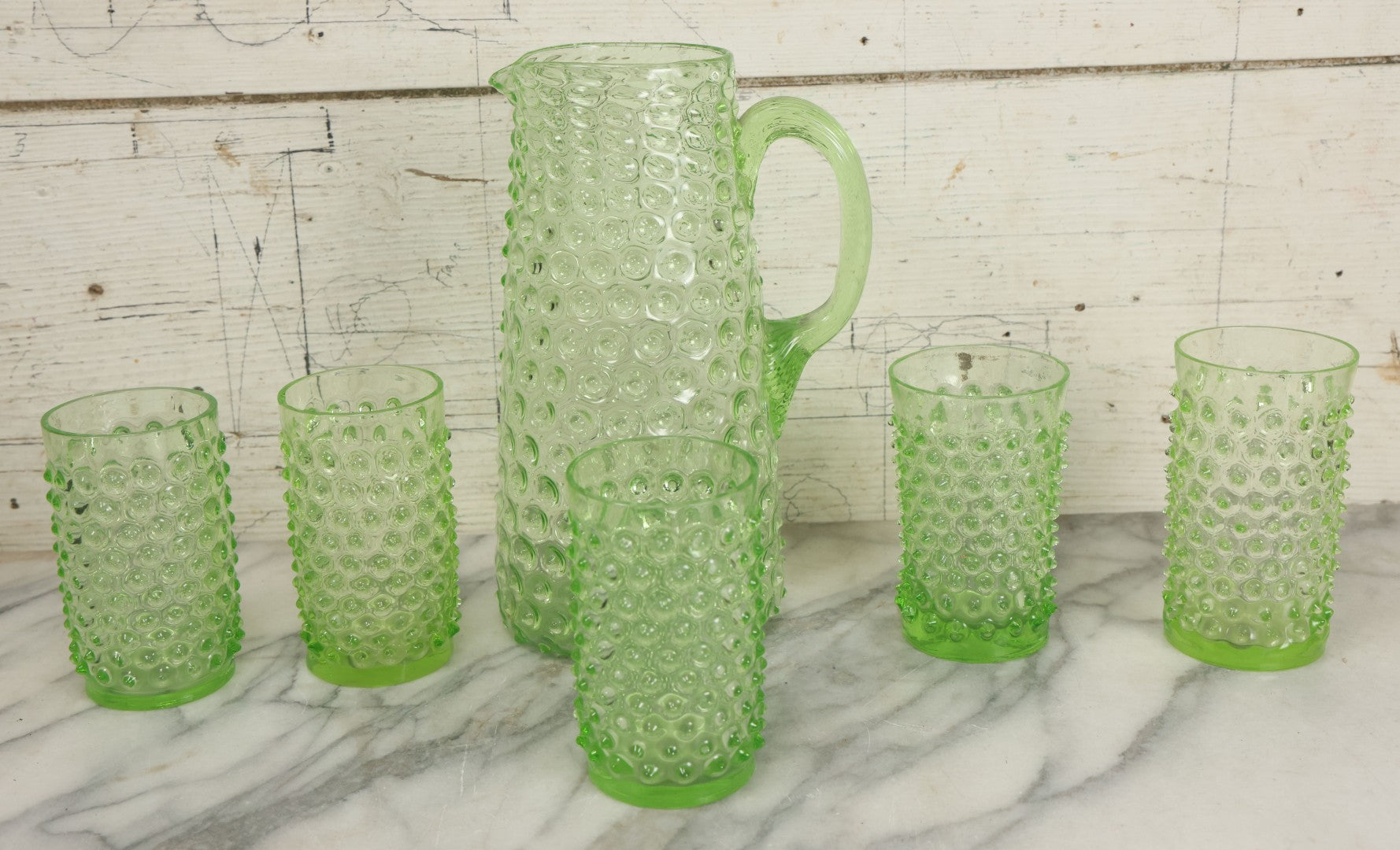 Lot 014 - Vintage Six Piece Hobnail Uranium Glass Drinking Collection With Pitcher And Four Matching Cups Plus Additional Cup, U.V. Blacklight Reactive Glass, Note Chips And Cracks