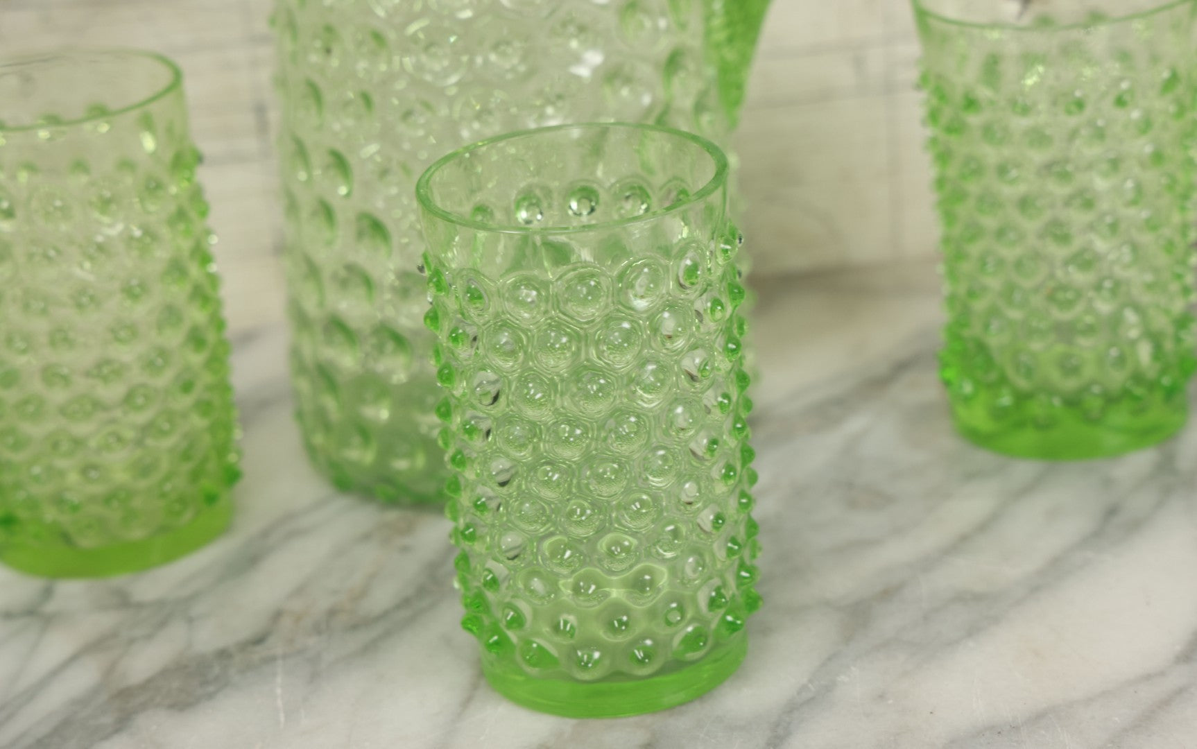 Lot 014 - Vintage Six Piece Hobnail Uranium Glass Drinking Collection With Pitcher And Four Matching Cups Plus Additional Cup, U.V. Blacklight Reactive Glass, Note Chips And Cracks