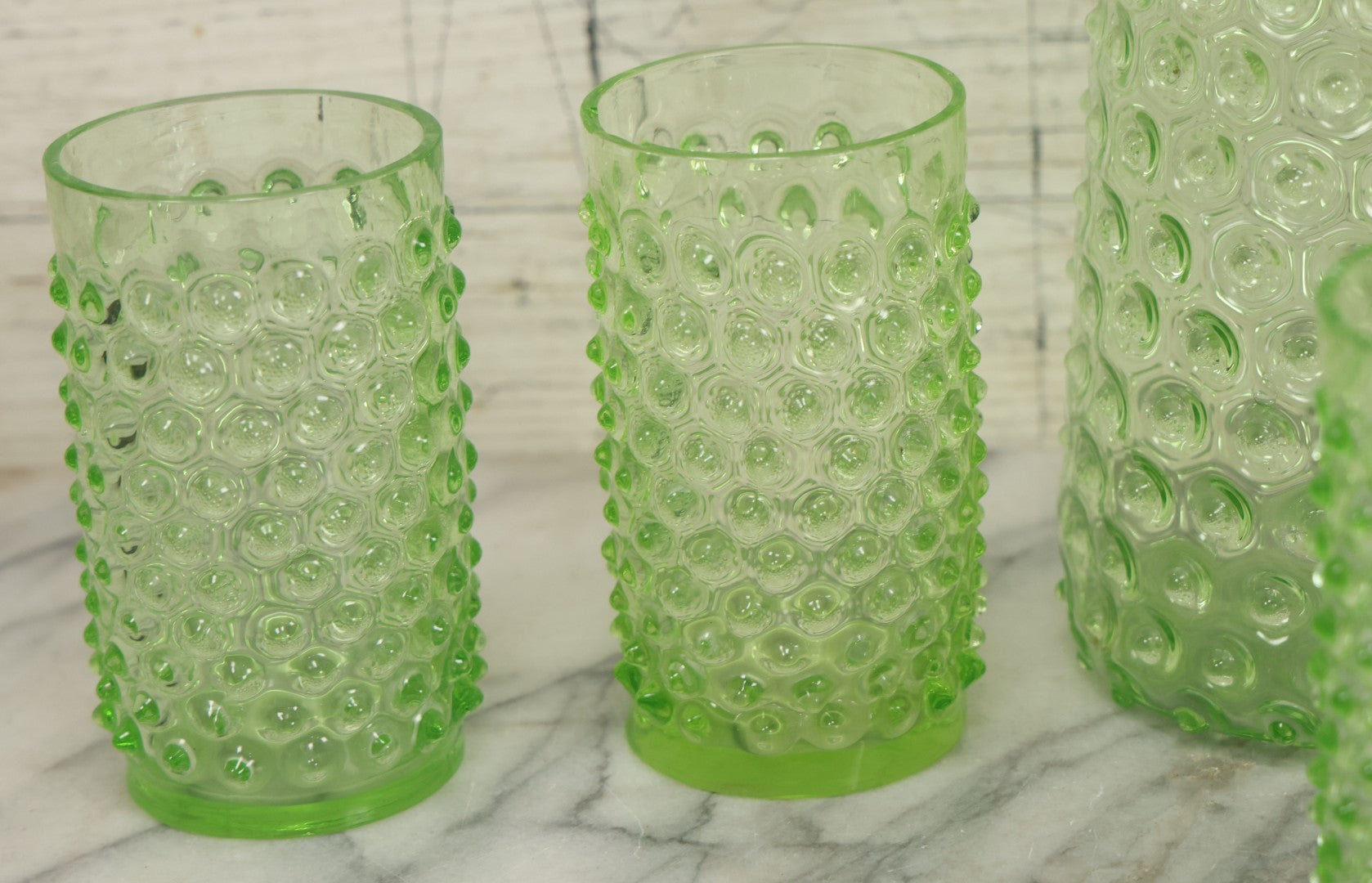 Lot 014 - Vintage Six Piece Hobnail Uranium Glass Drinking Collection With Pitcher And Four Matching Cups Plus Additional Cup, U.V. Blacklight Reactive Glass, Note Chips And Cracks