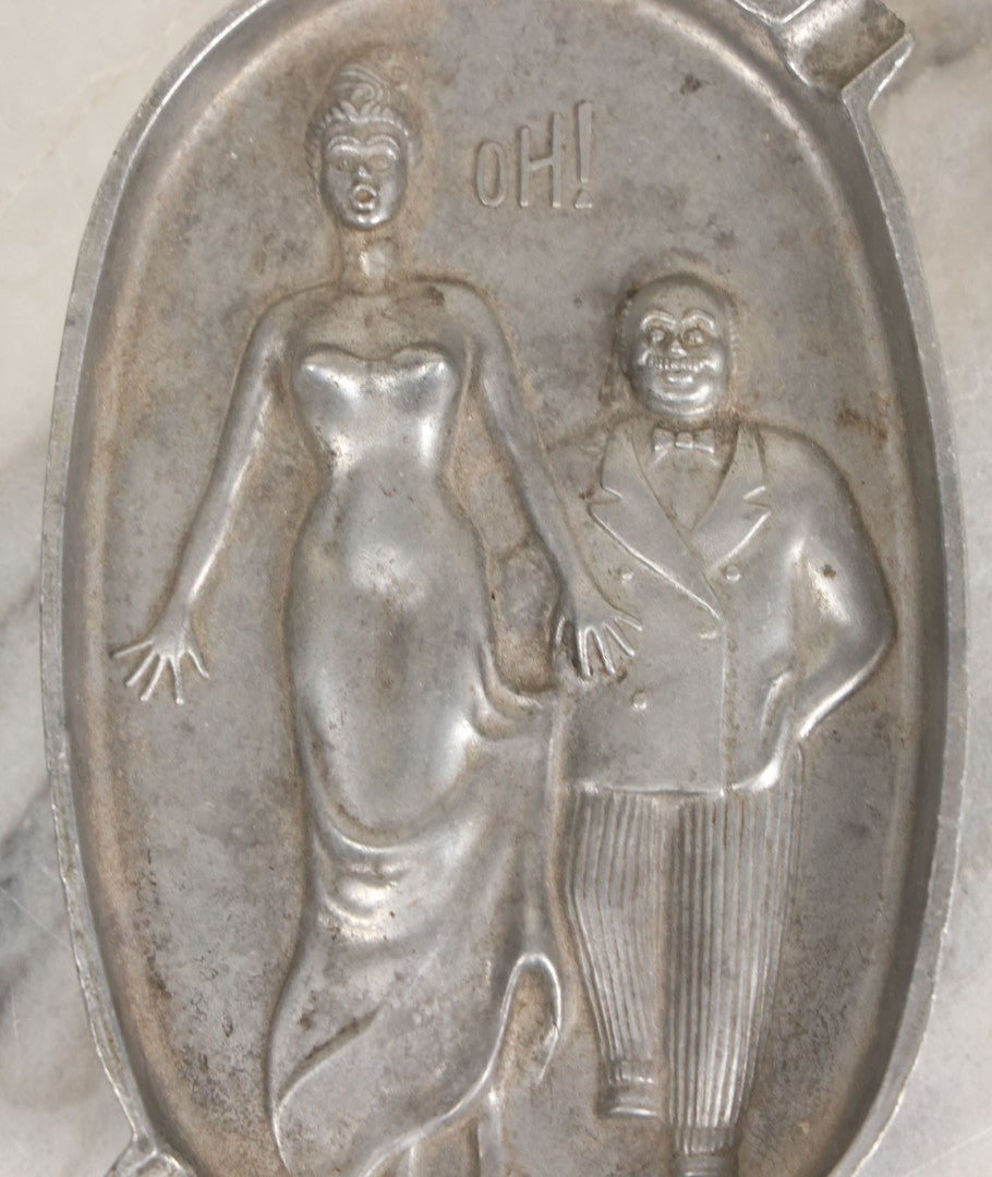 Lot 024 - Vintage Cast Aluminum "Oh! Ah!" Risqué Ashtray With Little Man Grabbing A Surprised Lady's Behind