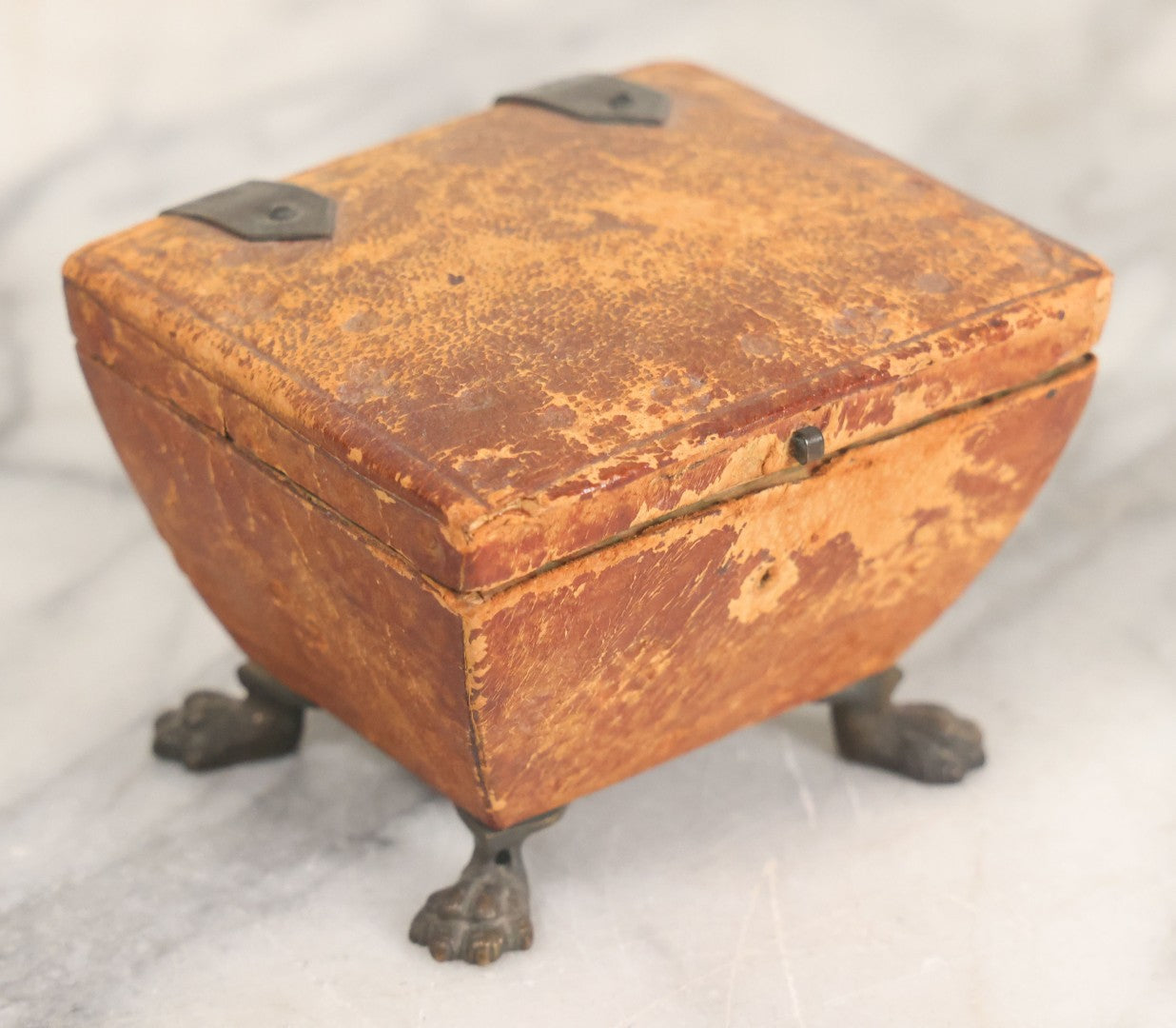 Lot 030 - Antique Leatherette Footed Stash Box With Paper Interior, Black Metal Strap Hinges, And Cloth Feet