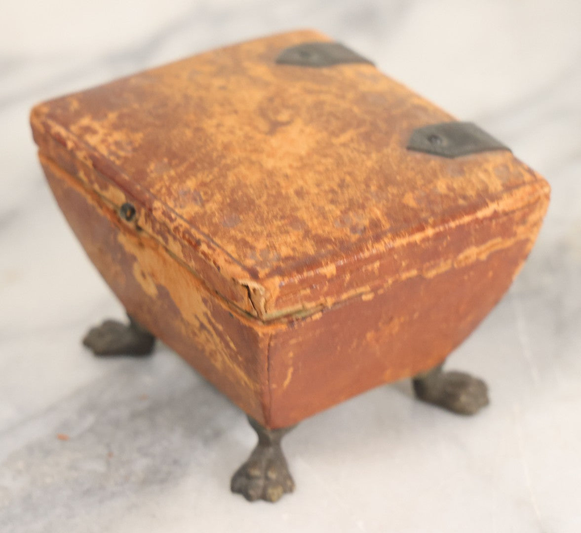 Lot 030 - Antique Leatherette Footed Stash Box With Paper Interior, Black Metal Strap Hinges, And Cloth Feet