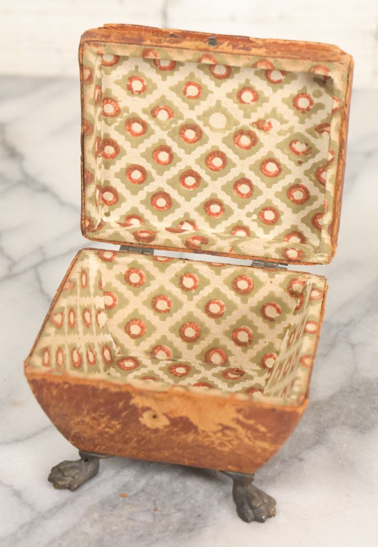 Lot 030 - Antique Leatherette Footed Stash Box With Paper Interior, Black Metal Strap Hinges, And Cloth Feet
