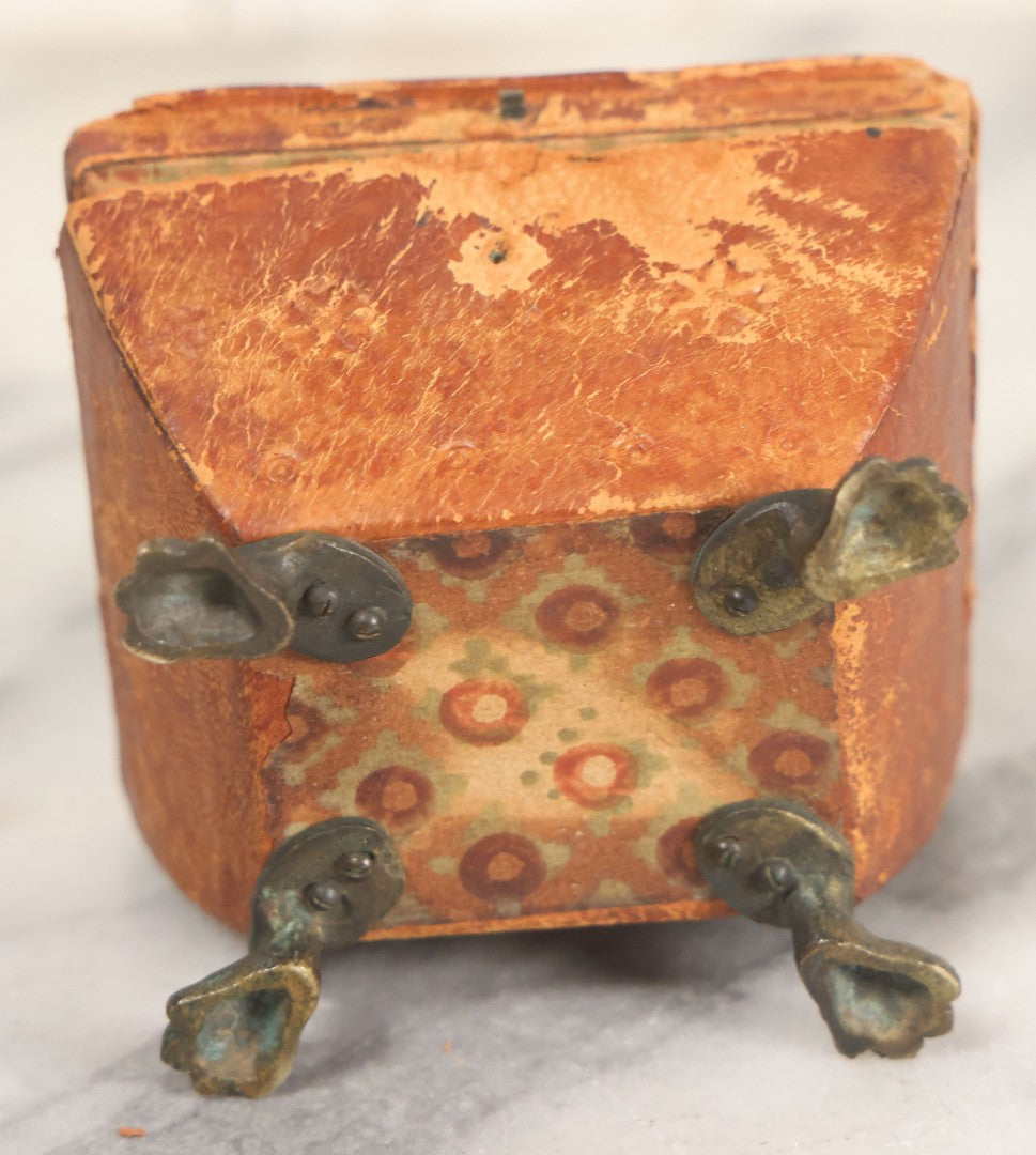 Lot 030 - Antique Leatherette Footed Stash Box With Paper Interior, Black Metal Strap Hinges, And Cloth Feet
