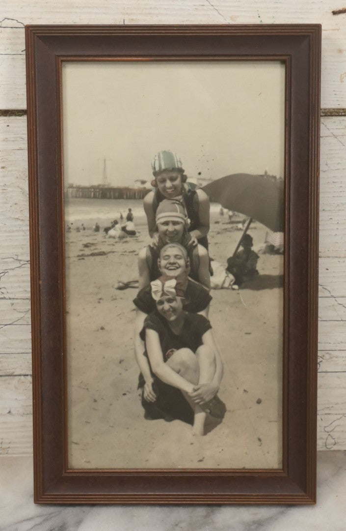 Lot 057 - Antique Tinted Photograph Of Three Ladies In Playful Pose On Beach With Pier In Background, Circa 1925, In Frame, 6-1/2" x 10-3/4"
