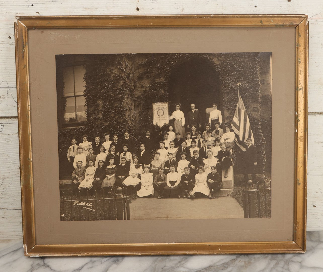 Lot 063 - Antique Boarded Photograph Of The Students And Staff Of The Messer Street Grammar School, Class Of 1893, Posing With Banner On School Steps, William Mills & Son, Photographers, Providence, Rhode Island, In Frame, 18-1/8" x 15-1/8"