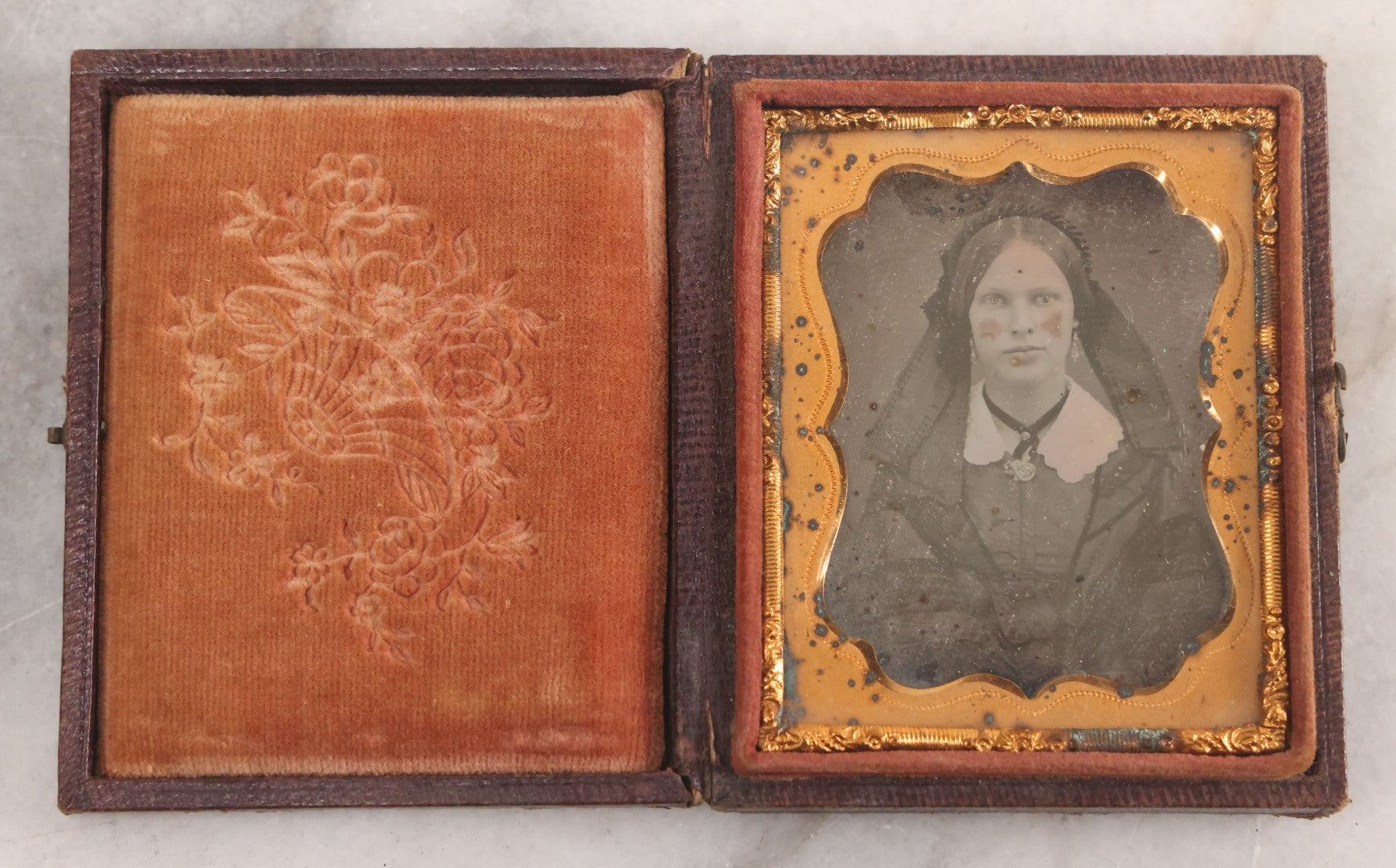 Lot 015 - Antique 1/9th Plate Daguerreotype Photograph Of Young Woman With Striking Eyes, White Collar, And Bonnet With Long Dark Lappets, In Full Intact Leatherette Union Case With Rose Motif