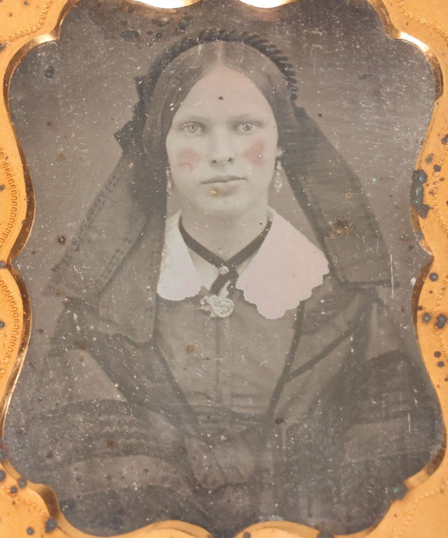 Lot 015 - Antique 1/9th Plate Daguerreotype Photograph Of Young Woman With Striking Eyes, White Collar, And Bonnet With Long Dark Lappets, In Full Intact Leatherette Union Case With Rose Motif