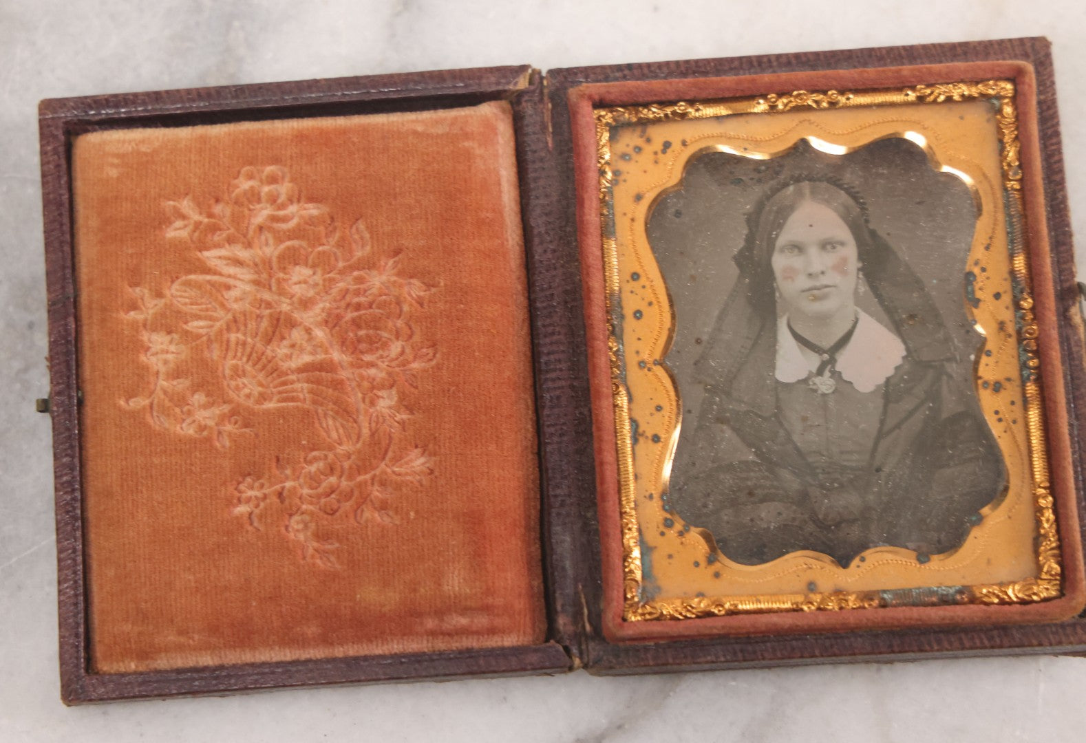 Lot 015 - Antique 1/9th Plate Daguerreotype Photograph Of Young Woman With Striking Eyes, White Collar, And Bonnet With Long Dark Lappets, In Full Intact Leatherette Union Case With Rose Motif