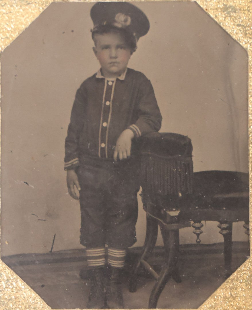 Lot 016 - Antique 1/6th Plate Tintype Photograph Of Young Boy Wearing Military Style Hat And Leaning Against Chair, In Full Intact Leatherette Union Case