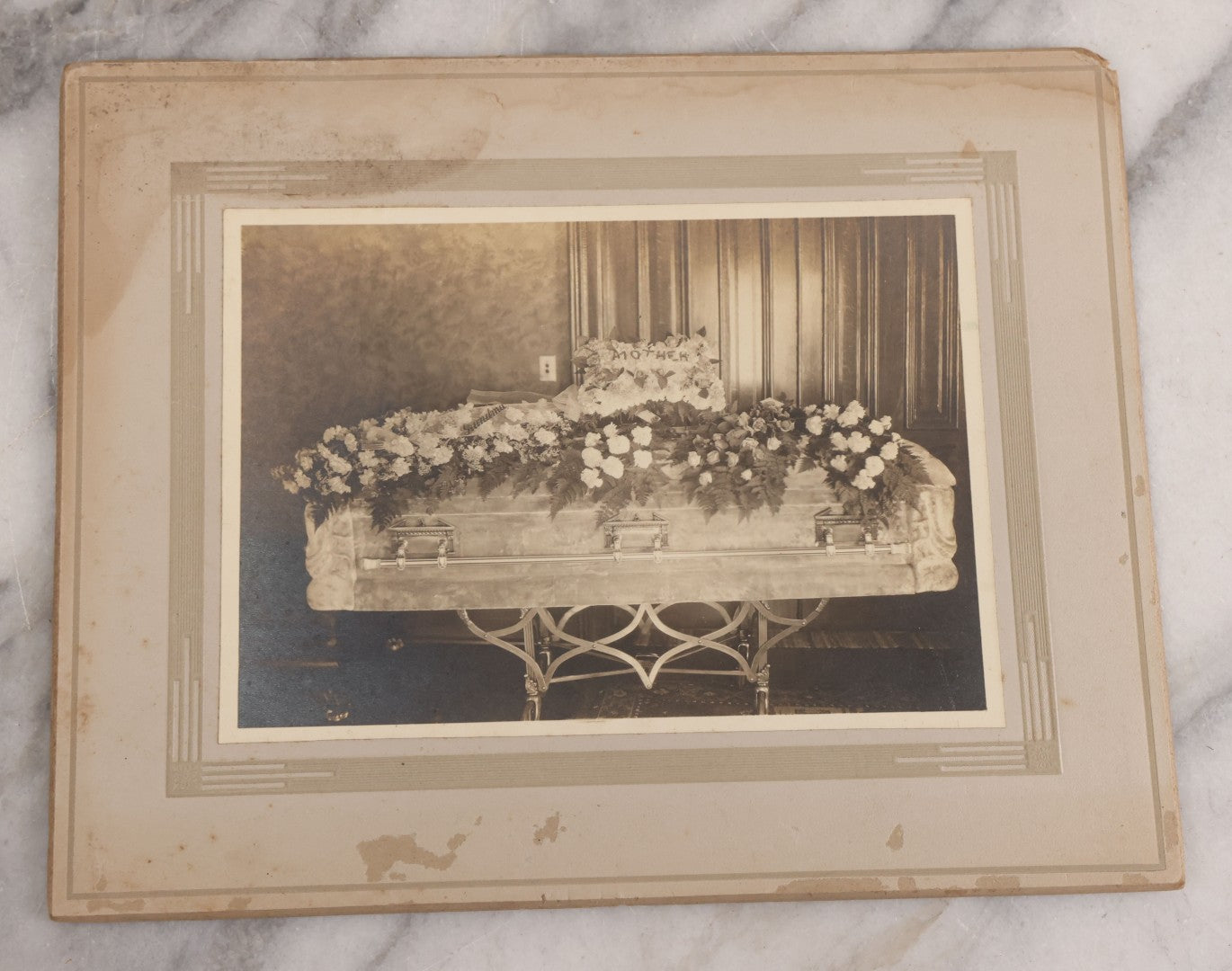 Lot 044 - Antique Boarded Funeral Photograph Of A Casket On Church Truck, Adorned With Flower Arrangements Including "Mother" Memorial