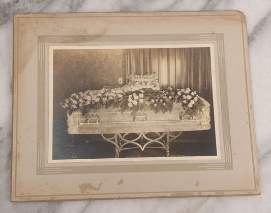 Lot 044 - Antique Boarded Funeral Photograph Of A Casket On Church Truck, Adorned With Flower Arrangements Including "Mother" Memorial