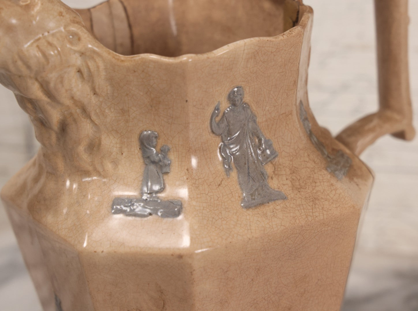 Lot 058 - Antique White Ironstone Pitcher With Figural Lion Head Spout, Blue Molded Neoclassical Figures, Note Damaged With Old Repairs, 9-3/4" Height