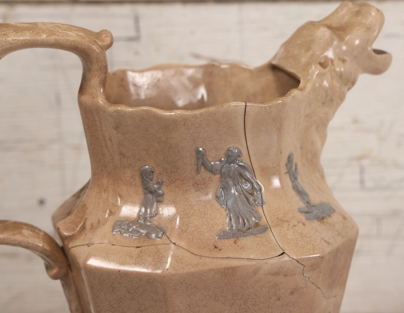 Lot 058 - Antique White Ironstone Pitcher With Figural Lion Head Spout, Blue Molded Neoclassical Figures, Note Damaged With Old Repairs, 9-3/4" Height